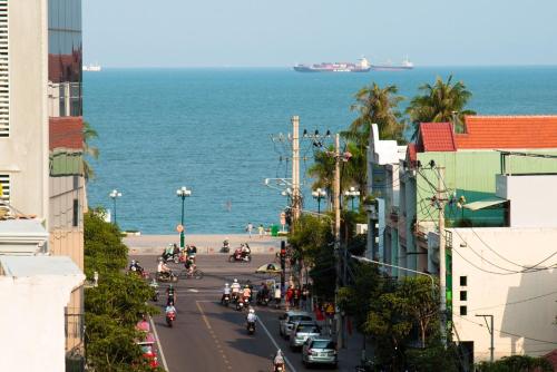 a busy city street with people riding motorcycles on the road at Hồng Gấm Hotel in Quy Nhon