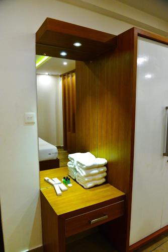 a bathroom with a mirror and a pile of towels at AURA RESIDENCY in Payyannūr
