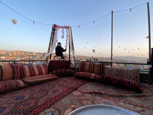a man sitting on a swing on the top of a building at View Cave Hotel in Göreme