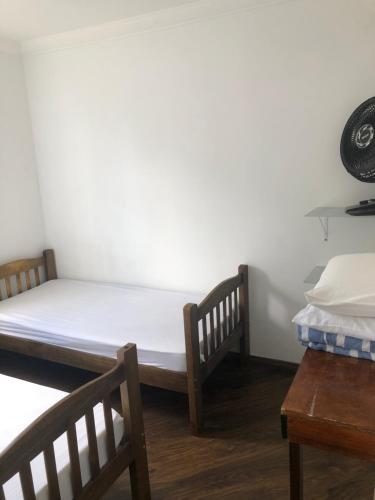 sypialnia z 2 łóżkami pojedynczymi i stołem w obiekcie Apartamento bem Localizado w São Paulo