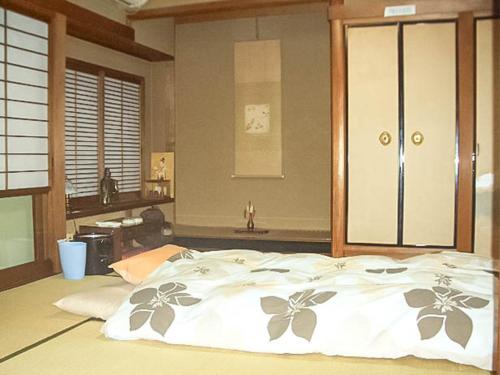 a bedroom with a bed with a clock on the wall at guest house AN in Otsu