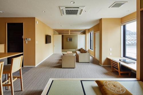 ein Wohnzimmer mit einem Sofa und einem Tisch in der Unterkunft Onsen no yado Gion Maisen Bettei by YADORU KYOTO HANARE in Kyoto