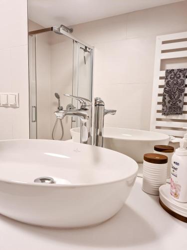 a white bathroom with a sink and a tub at Apartment 1007 Rogowo Pearl in Mrzeżyno