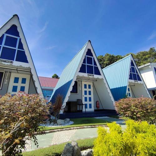 a house with triangular roofs with a yard at Nipah Guesthouse Pangkor in Pangkor
