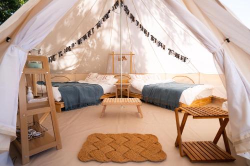 a bedroom with two beds in a tent at 分校Stay haruhi グランピング in Ureshino