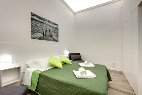 a bedroom with a green bed with two towels on it at Nise Duomo apartment in Florence