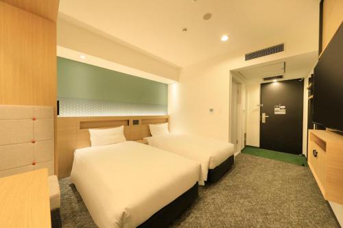 a hotel room with two beds and a television at Via Inn Prime Akasaka in Tokyo