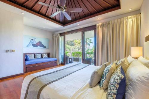 a bedroom with a large bed with a ceiling fan at Kejora Beachfront Estate Sanur -Stunning Villa Eleven in Sanur