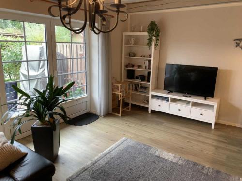 a living room with a flat screen tv and a large window at Huus Utspann in Nordstrand