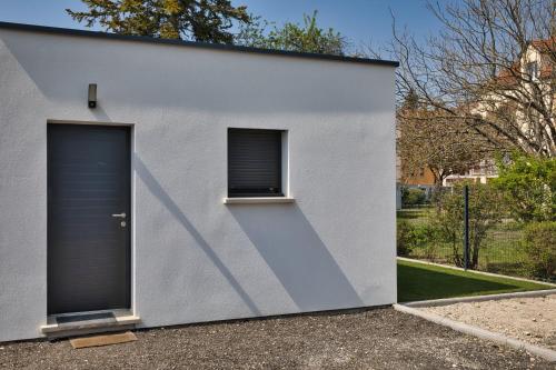 une maison blanche avec une porte bleue et une fenêtre dans l'établissement L'à Côté, à Colmar