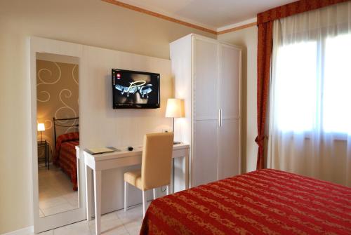 a hotel room with a desk and a bed at Hotel Eden Salò in Salò