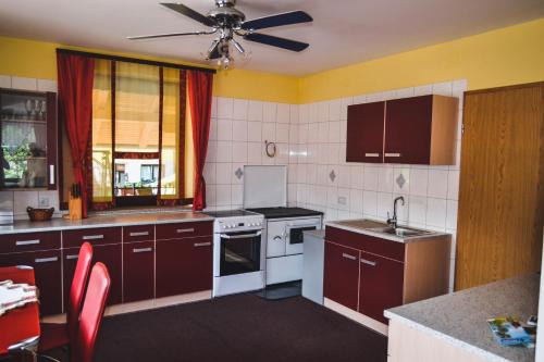 een keuken met bruine kasten en een plafondventilator bij Apartmaji Krebs in Mežica