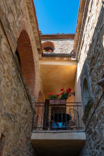 an alley with a balcony with flowers on it at Monastero San Silvestro in Cortona