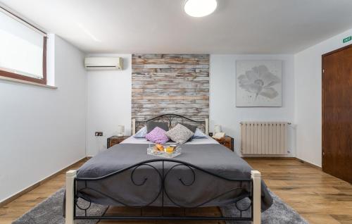 a bedroom with a bed and a brick wall at Apartments Ariana in Umag