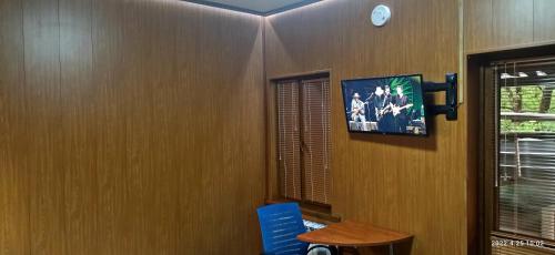 アルマトイにあるApartment in a guest houseの壁にテレビとテーブルが備わる客室です。