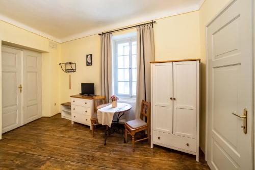 Zimmer mit einem Tisch, einem Schreibtisch und einem Fenster in der Unterkunft Penzion Thallerův Dům in Český Krumlov