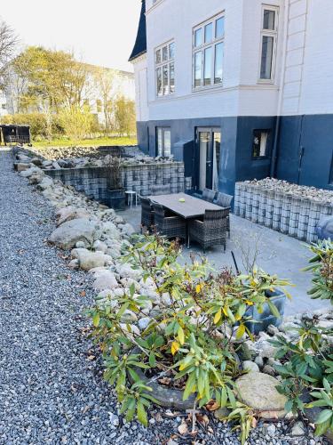 a house with a table in front of a building at aday - Central Charming Apartment with Terrace in Aalborg