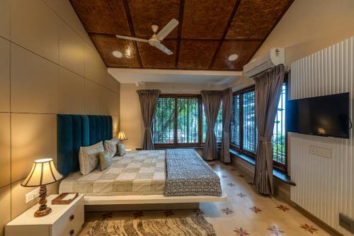 a bedroom with a bed and a ceiling fan at SaffronStays Verandah by the Valley, Panchgani - luxury villa and treehouse with beautiful valley and lake views in Panchgani
