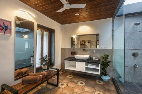 a bathroom with a sink and a glass shower at SaffronStays Verandah by the Valley, Panchgani - luxury villa and treehouse with beautiful valley and lake views in Panchgani