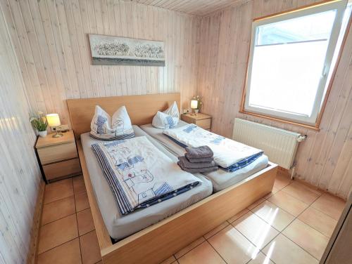 een slaapkamer met een bed met 2 nachtkastjes en een raam bij Ferienhaus Sellin in Ostseebad Sellin