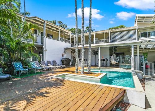 een huis met een zwembad en een houten terras bij Noosa Flashpackers in Sunshine Beach