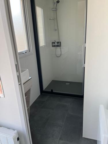 een badkamer met een douche en een glazen deur bij LE PIPA in Quend