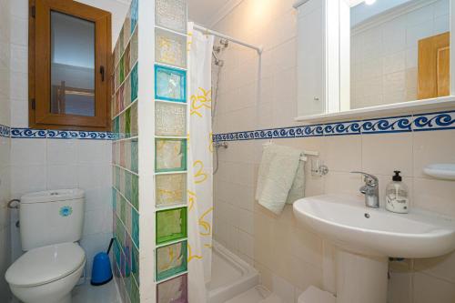 a bathroom with a sink and a toilet and a mirror at Casa Meli in Finestrat