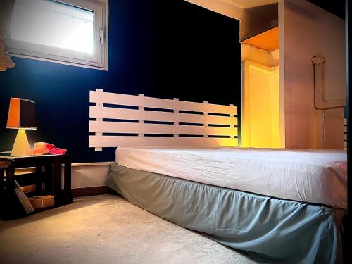 une chambre avec un lit blanc avec une fenêtre dans l'établissement Appartement mezzanine/jardin/terrasse village naturiste, au Cap d'Agde