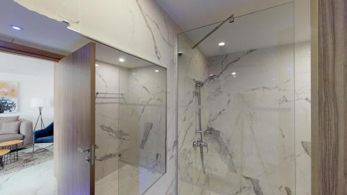 a bathroom with a shower with marble walls at The Blue Ivy Hotel & Suites in Protaras