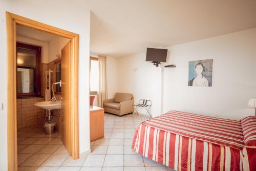 ein Hotelzimmer mit einem Bett und einem Bad in der Unterkunft Albergo Luna di Marzo in Volastra