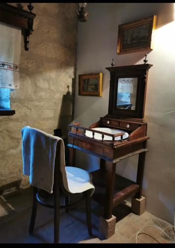 a wooden piano with a chair and a mirror at Kusper Vendégház 1846 in Bükkzsérc