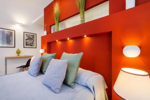 a bedroom with an orange accent wall and a bed with pillows at ReLuxe Private Wellness in Lecce