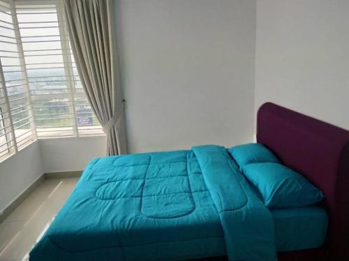a blue bed in a room with a window at Lovely 2 bed-room Menara U Shah Alam near MSU in Shah Alam