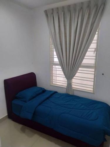 a bedroom with a blue bed and a window at Lovely 2 bed-room Menara U Shah Alam near MSU in Shah Alam
