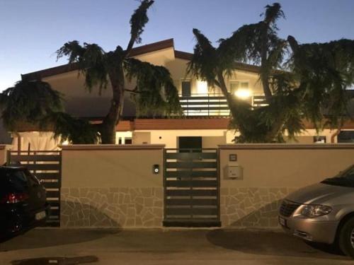 une voiture garée devant une maison avec garage dans l'établissement Appartamento in Villa, à Marina di Ginosa