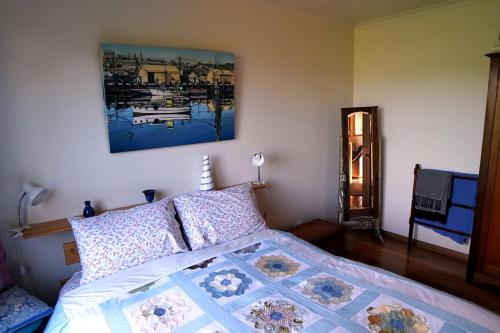 1 dormitorio con 1 cama y una pintura en la pared en 19 Blue, en Kingston Beach
