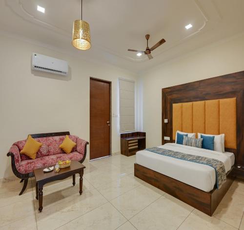 a bedroom with a large bed and a couch at Red Tullip MD Valley Resort and Spa in Udaipur