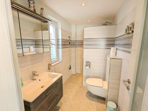 een badkamer met een wastafel, een toilet en een bad bij Ferienhaus Sellin in Ostseebad Sellin