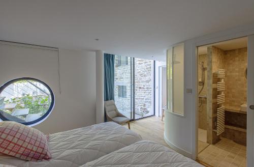 une chambre avec un lit et une salle de bain avec une fenêtre dans l'établissement Villa Ty Sant Buzit, à Pont-Aven