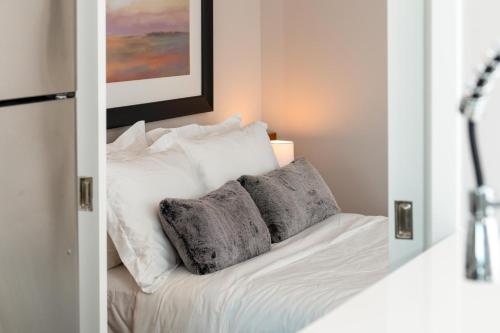 a bedroom with a bed with two pillows and a mirror at Luxury Apartments by Hyatus at Pierpont in New Haven