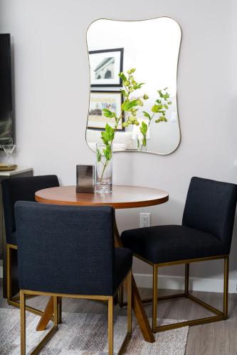 a dining room table with two chairs and a mirror at Luxury Apartments by Hyatus at Pierpont in New Haven