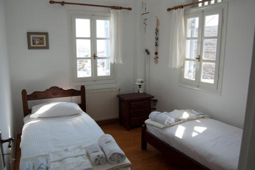 a bedroom with two beds and two windows at Panormos Villa Tinos Greece - Traditional House in Pánormos