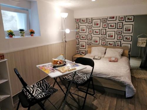 Cette chambre comprend un lit et une table avec des chaises. dans l'établissement Guest House dans jardin exotique proche d'une voie verte, à Morlaix