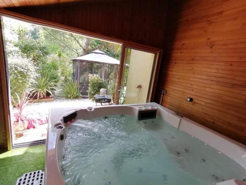 Cette chambre dispose d'un bain à remous et d'une grande fenêtre. dans l'établissement Guest House dans jardin exotique proche d'une voie verte, à Morlaix
