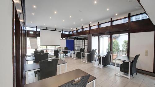 a large room with tables and chairs and windows at Hotel Spahr in Stuttgart