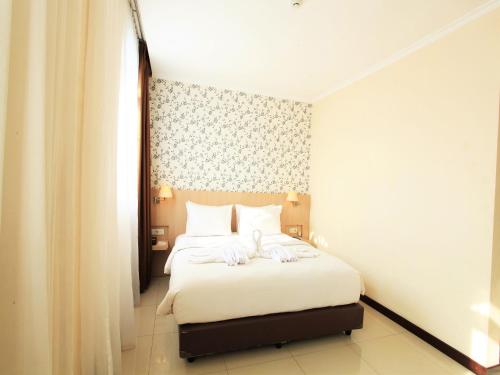 a hotel room with a bed with towels on it at Rio City Hotel in Palembang