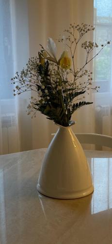 een gele vaas met bloemen erin op een tafel bij Casa Vacanze “Il Sogno” in Bagnoregio