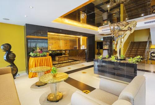パタヤ・セントラルにあるNova Gold Hotel Pattayaのホテルのロビー(椅子、テーブル付)