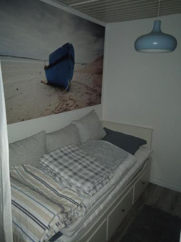 a bed in a room with a painting on the wall at Ferienbungalow FeWo Eutin Süsel Sierksdorf Strand Ostsee in Süsel