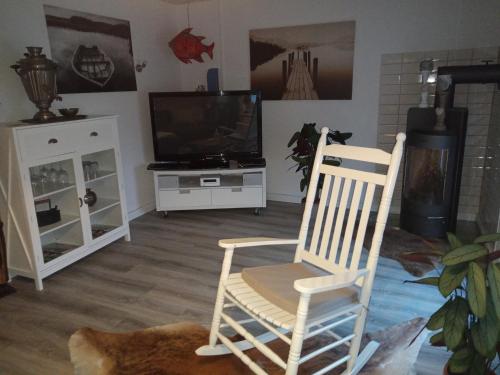 a living room with a rocking chair and a television at Ferienbungalow FeWo Eutin Süsel Sierksdorf Strand Ostsee in Süsel